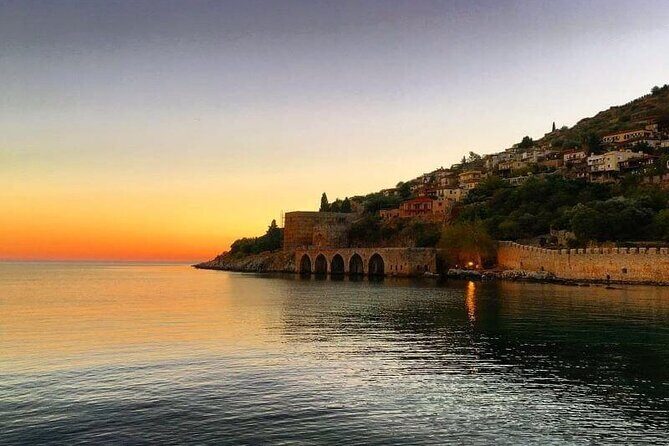 Sunset Boat Trip Along the coast of Alanya - Alanya Harbor scenery: Red Tower, shipyard, and Cleopatra Beach from a distance
